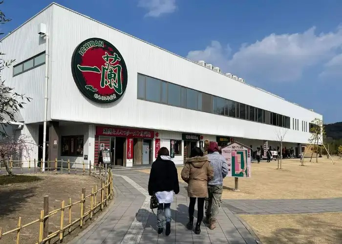 Three people walking into the Ichiran Ramen Factory in Itoshima.